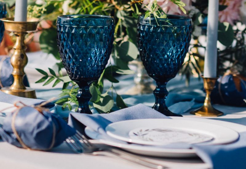 a glass with a blue vase on a table